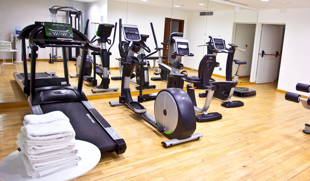 Fitness facilities in a Tenerife gym with exercise bikes and treadmills.