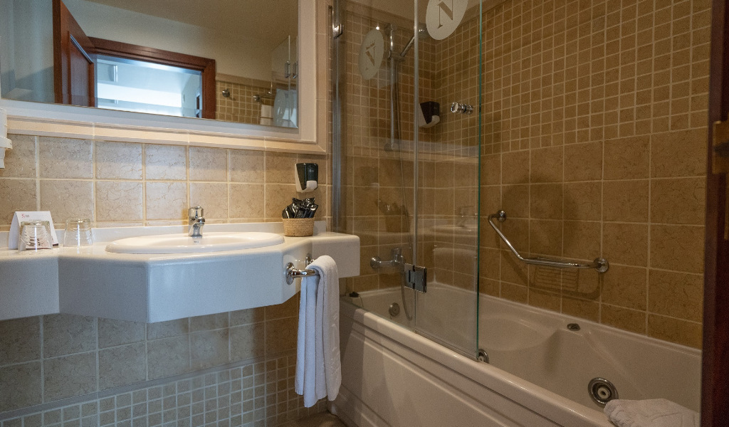 Bathroom with sink, towel, and bathtub in a hotel room in Tenerife.