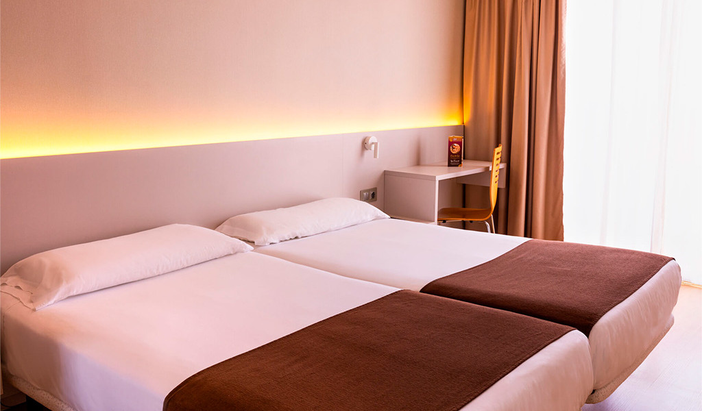 Two single beds with brown covers in a hotel room in Tenerife.