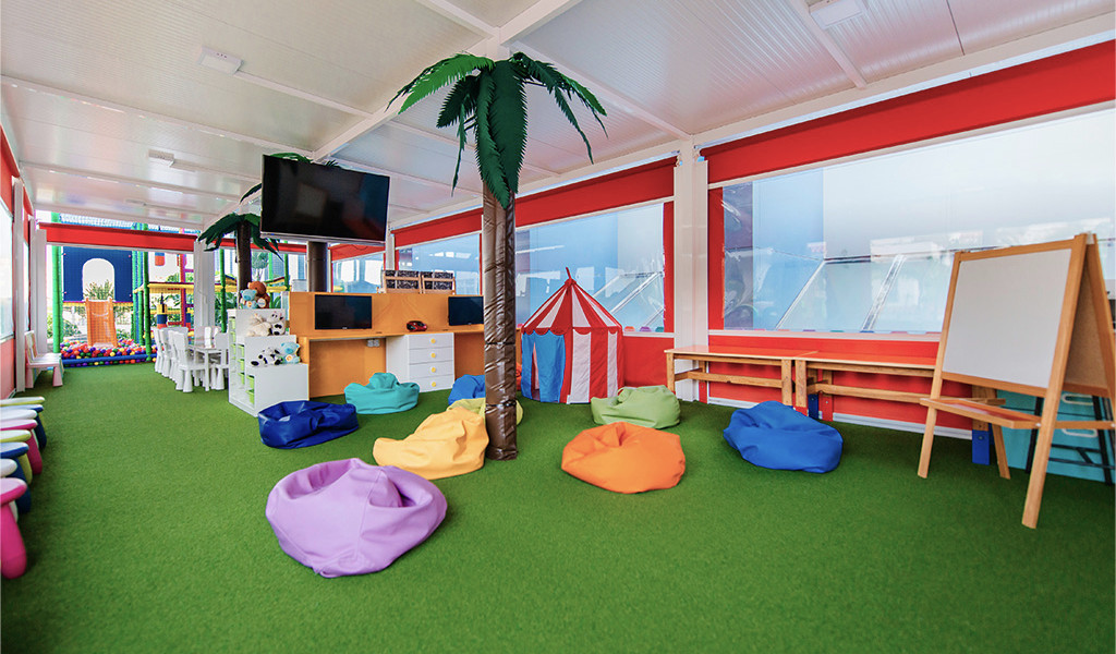 Playroom with colorful bean bags, small tables, and a palm tree in Tenerife.