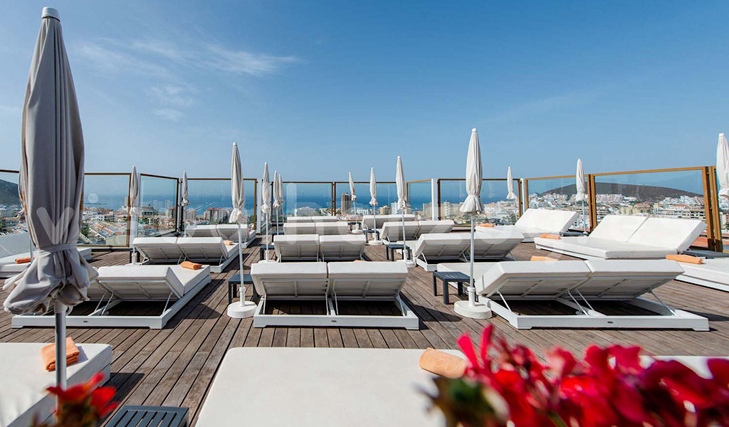 Sun loungers on a rooftop terrace overlooking the ocean in Tenerife.