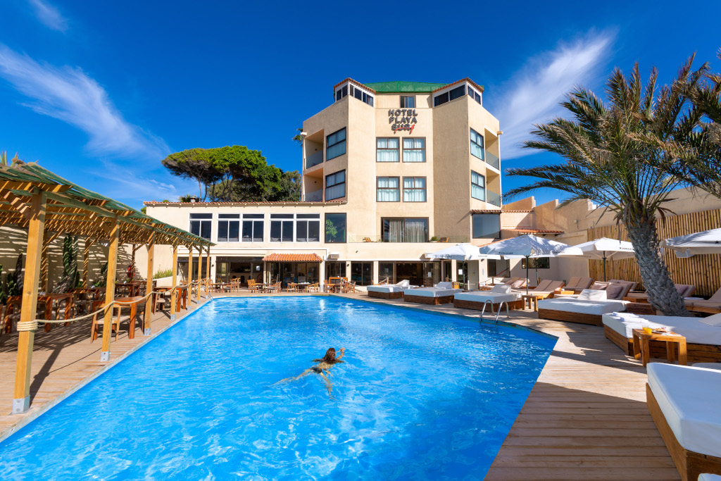 Outdoor pool area of Hotel Casa, Santa Cruz de Tenerife, with sunbeds and palm trees.