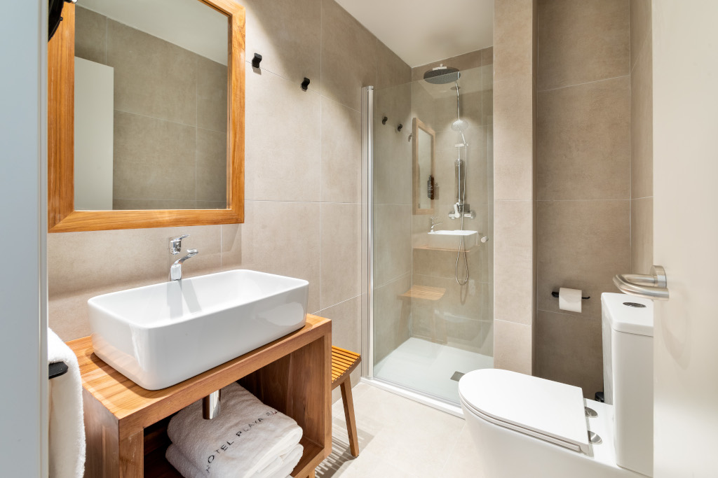 Modern bathroom with shower, sink, and mirror in Tenerife hotel.