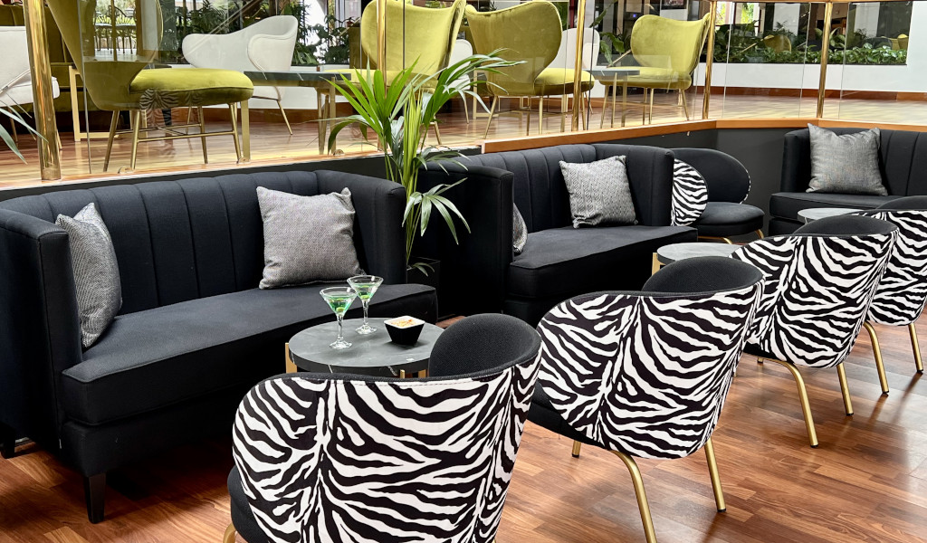 Elegant living room with black sofas and zebra chairs in Tenerife.