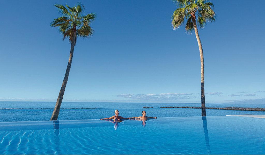 Person enjoying themselves in an infinity pool overlooking the ocean in Tenerife.