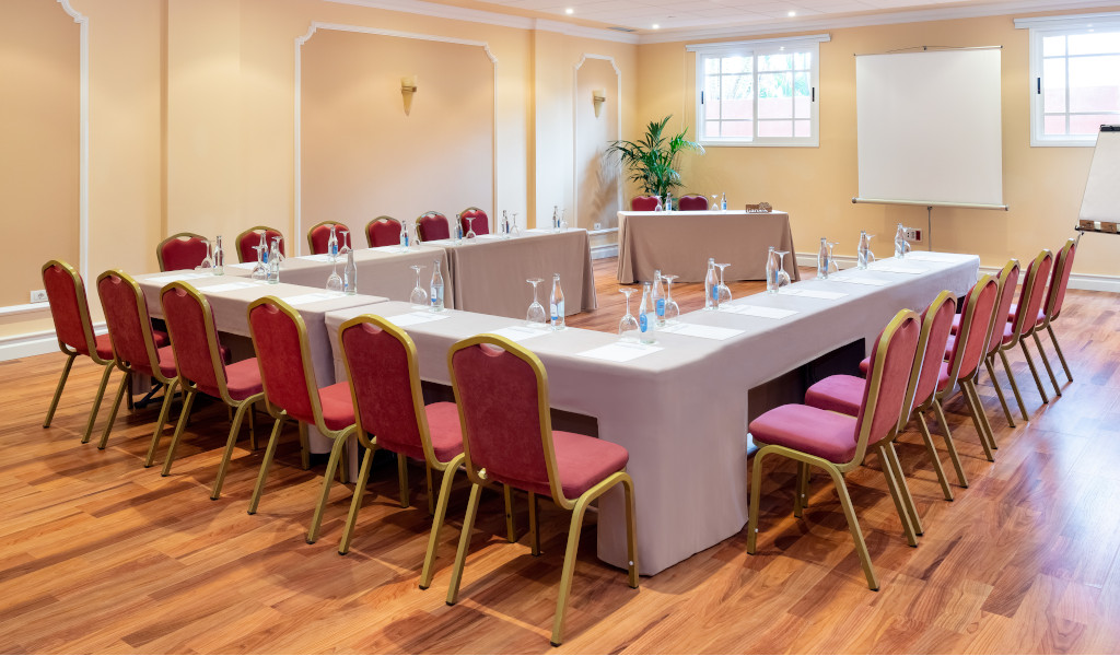 Meeting room with U-shaped table and chairs, notepads, and water bottles in Tenerife.