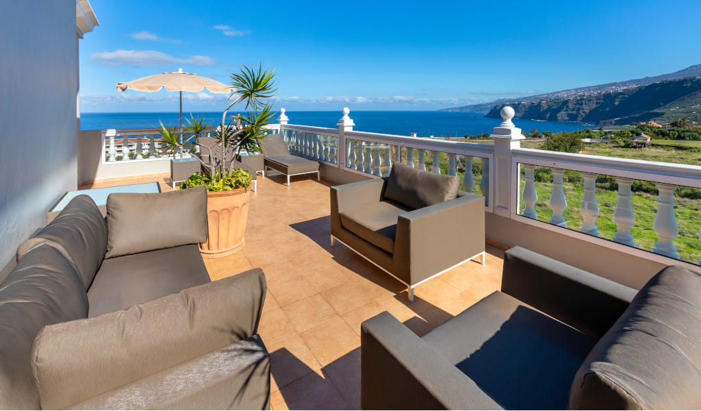 Terrace with sofas overlooking the ocean and mountains in Tenerife.
