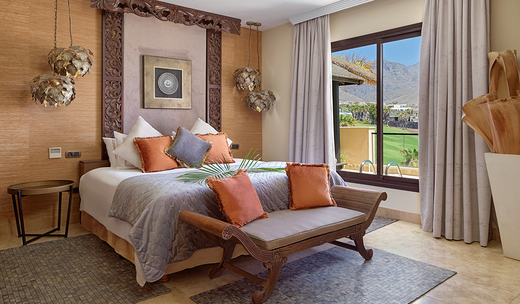 Bedroom in Tenerife hotel with mountain view through window.