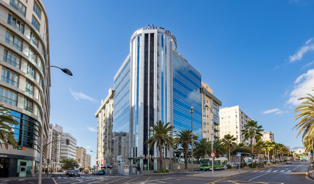 Modern building on a busy street in Santa Cruz de Tenerife with blue skies.