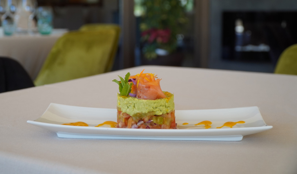 Elegant dish with avocado and salmon tartare served on a white plate in Tenerife restaurant.