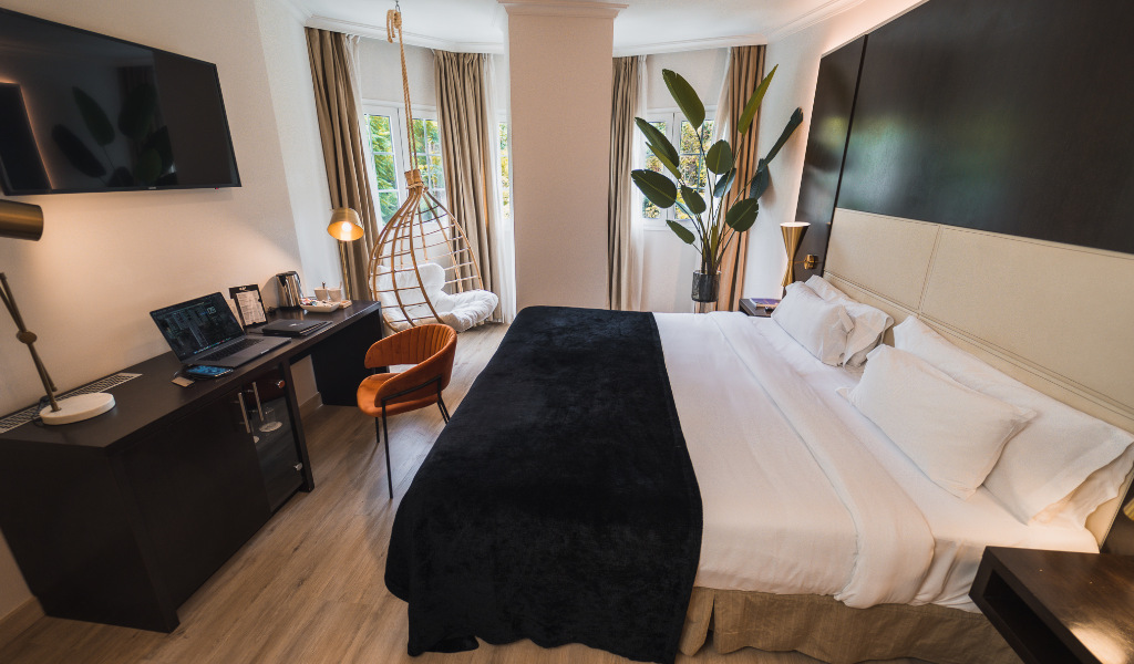 Hotel room with king-sized bed, desk with laptop, and chair in Santa Cruz de Tenerife.