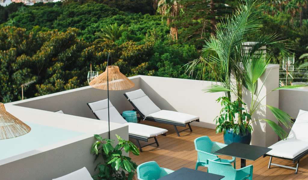 Rooftop terrace with sun loungers, plants, and a table in Tenerife.