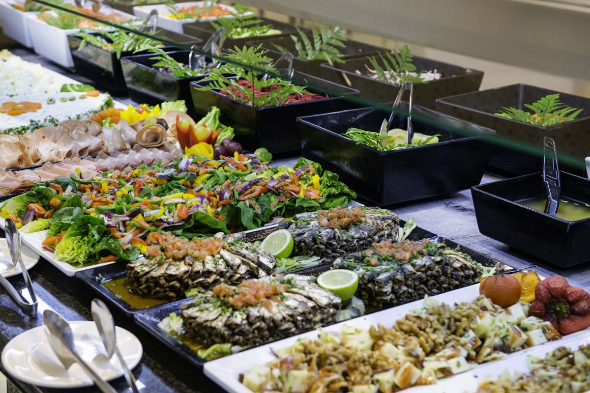 Assorted dishes with salads, meats, and garnishes at a buffet in Tenerife.