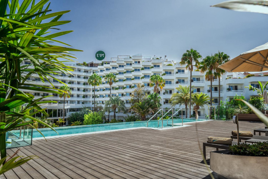 Outdoor pool and sun deck with hotel building in Tenerife.