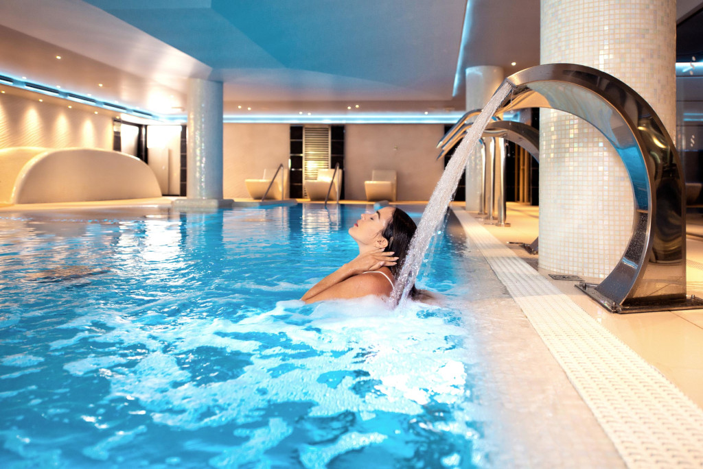 Woman under water jet in indoor pool at a Tenerife spa.