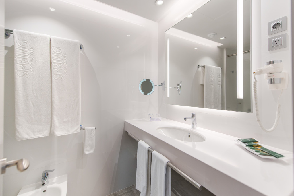 Modern bathroom with sink, towels labeled Spring Hotels, mirror, and hairdryer in Tenerife.