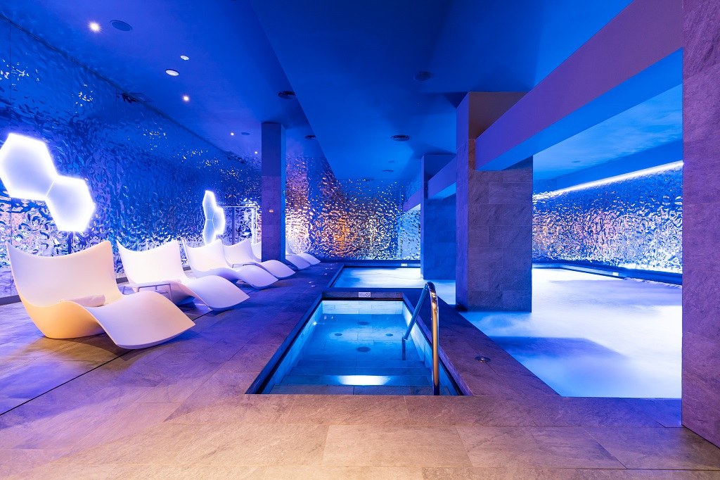 Indoor spa with modern lounge chairs and illuminated pool in Tenerife.