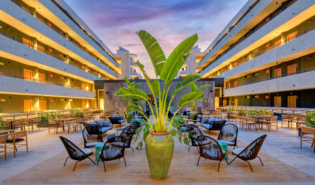 Courtyard with potted plants and chairs at a hotel in Tenerife at sunset.