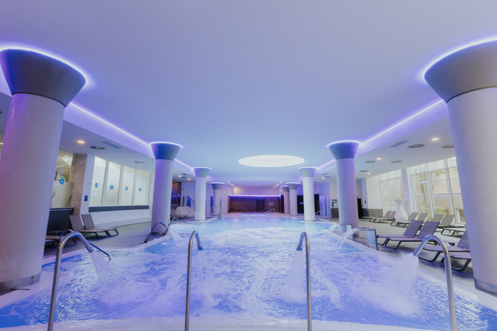 Indoor pool with lounge chairs and water jets at a spa in Tenerife.