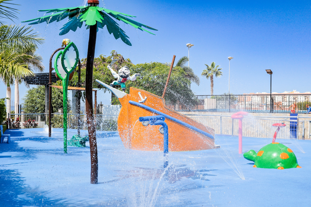Children's splash park with water features and palm trees in Tenerife.