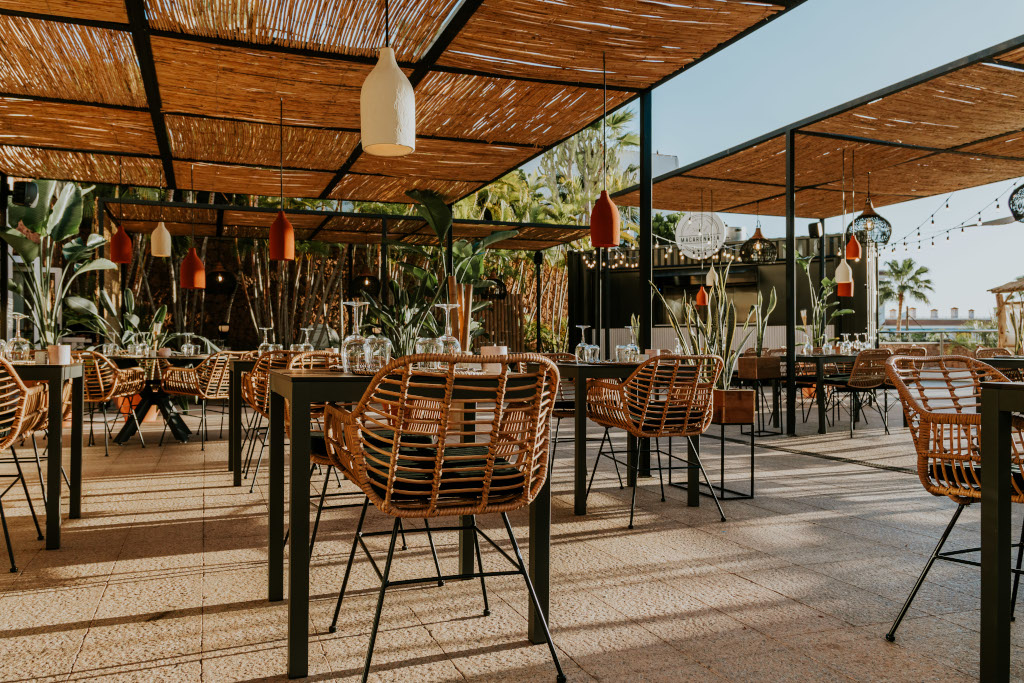 Outdoor restaurant seating area with wicker chairs and tables in Tenerife.