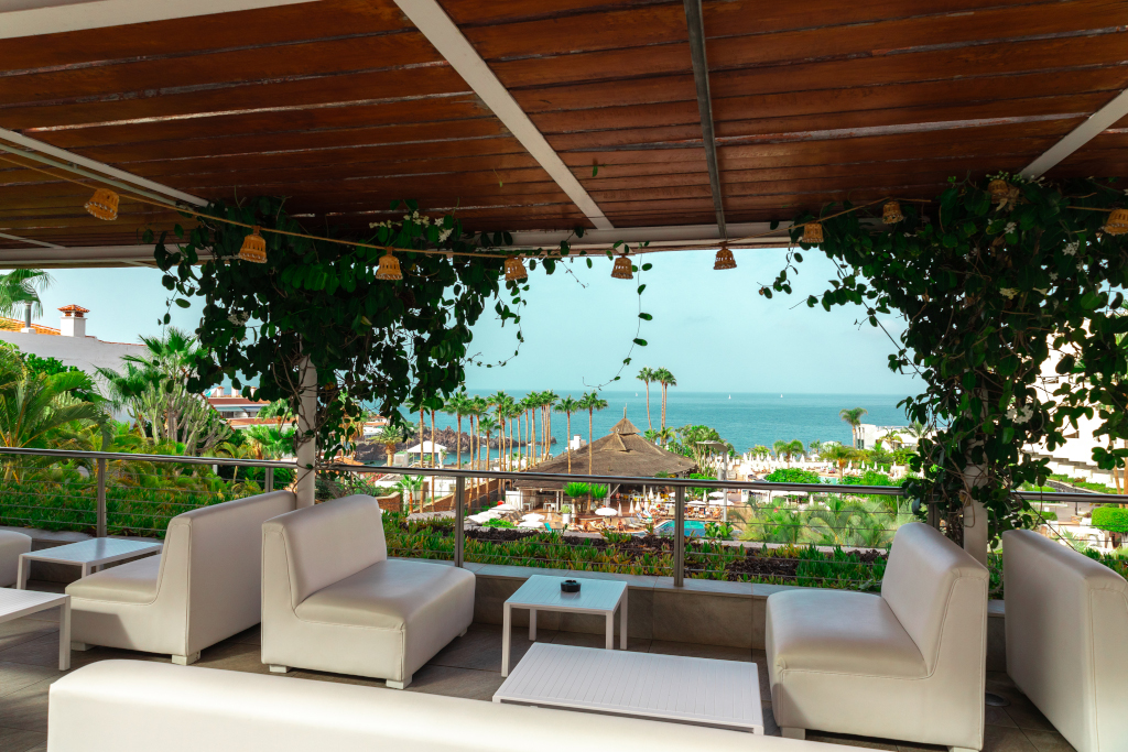 Terrace view with white sofas overlooking Costa Adeje and the ocean in Tenerife.