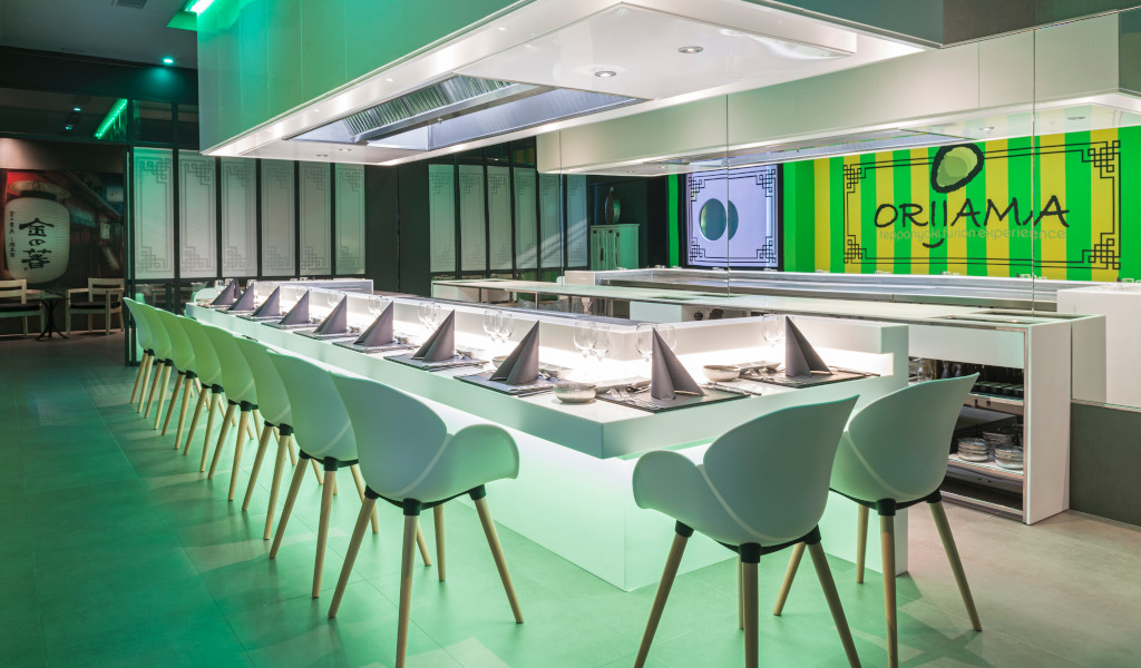 Kitchen area with neatly arranged dining table and chairs, Oriama sign on wall in Tenerife.