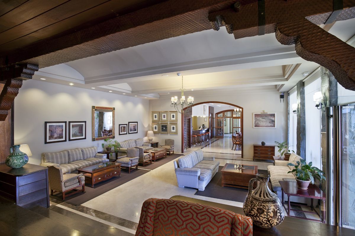 Spacious hotel lobby in Tenerife with sofas, tables, and framed pictures on walls.