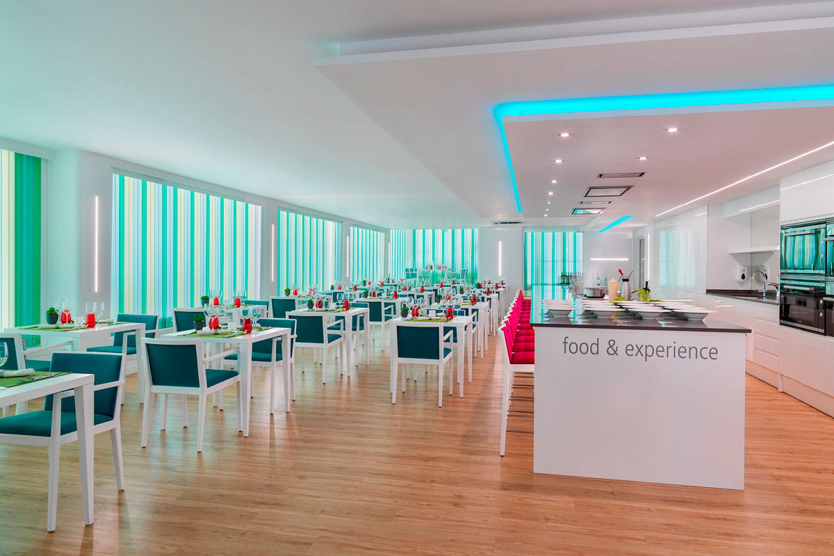 Modern dining space with set tables and counter saying food & experience in Tenerife.