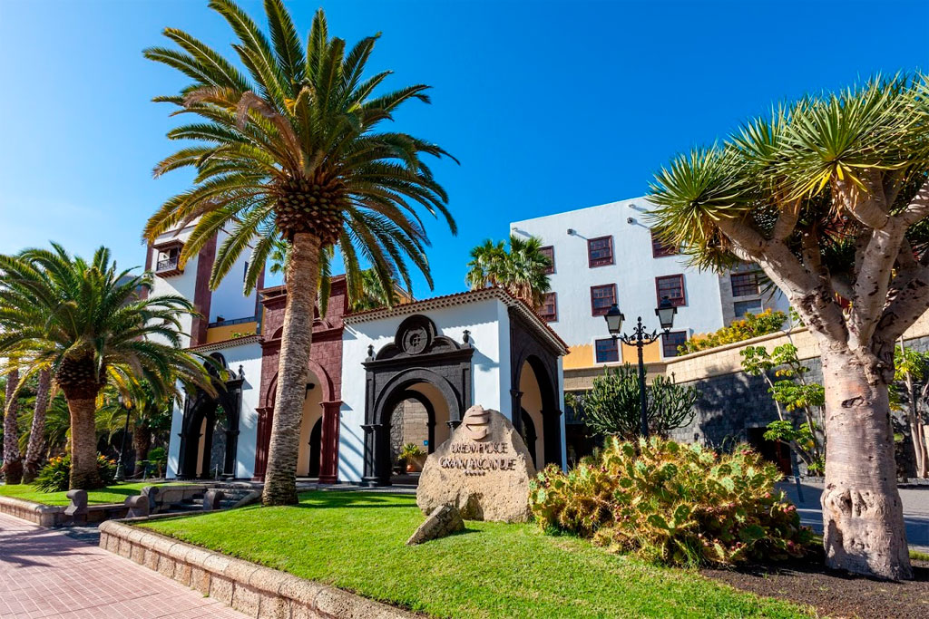 Historic building with palm trees and cacti in San Cristóbal de La Laguna, Tenerife.