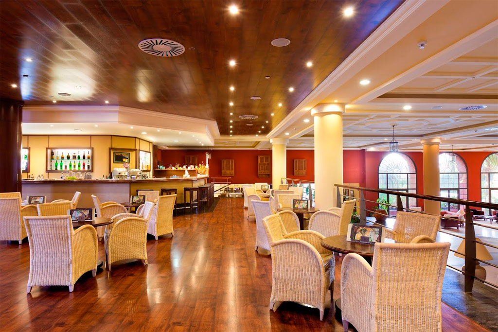 Spacious lounge area with wicker chairs and wooden floor in Tenerife.