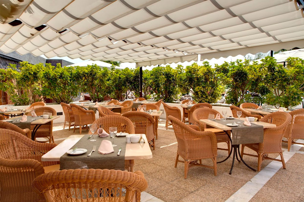 Outdoor dining area with tables and wicker chairs at a restaurant in Tenerife.