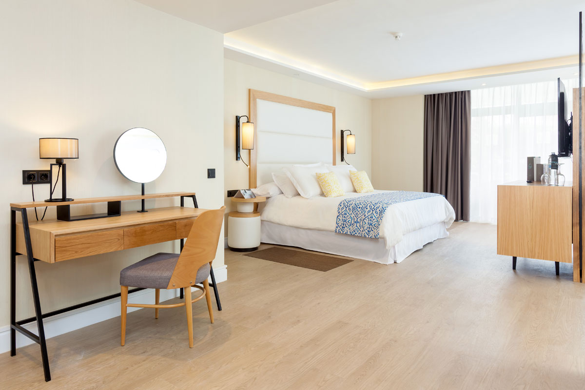 Hotel room with a bed, desk, and chair in Tenerife, featuring elegant decor.