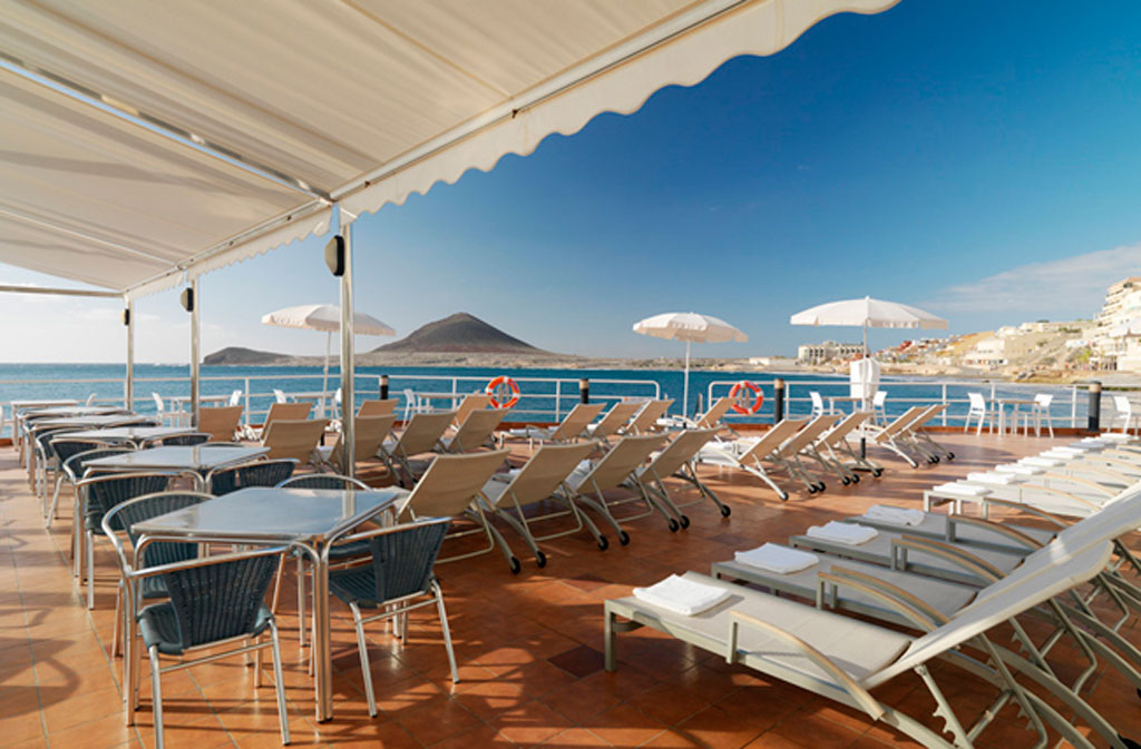 Sun loungers and tables on a terrace overlooking the sea in El Médano, Tenerife.
