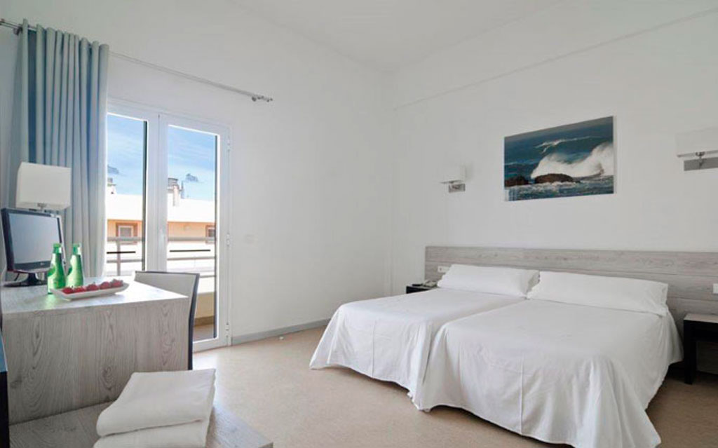 Hotel room with two beds in Puerto de la Cruz, Tenerife, includes table and view through window.