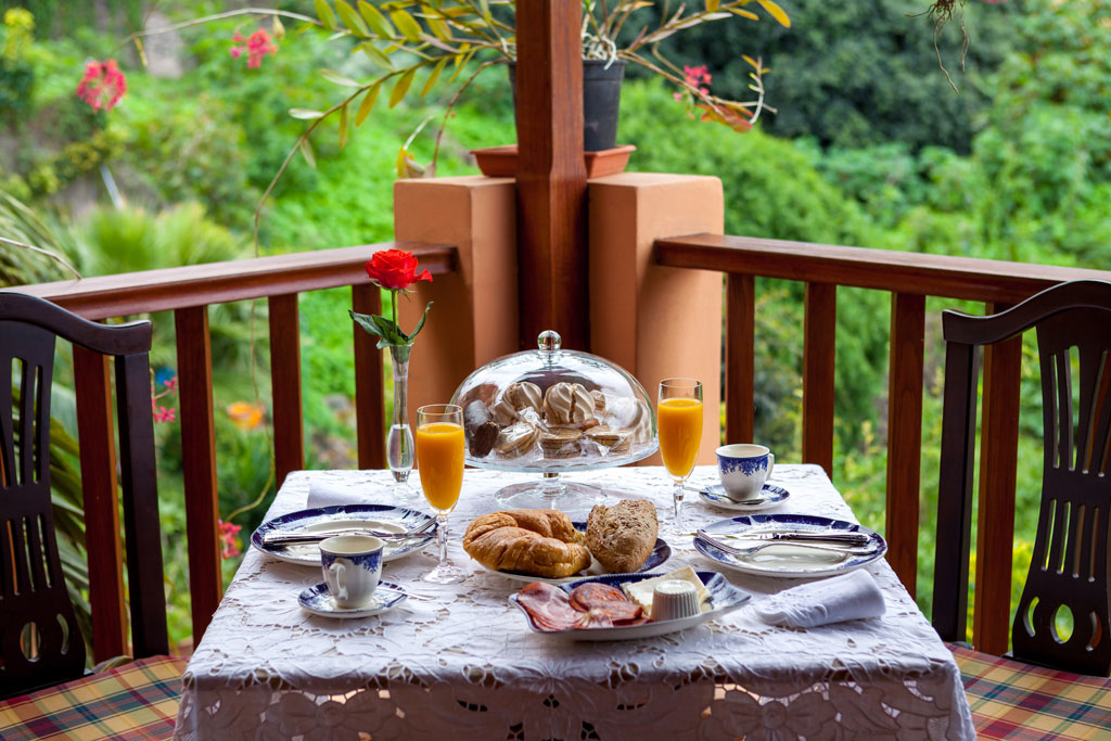 Breakfast table with pastries, juice, and coffee on a terrace in Tenerife.