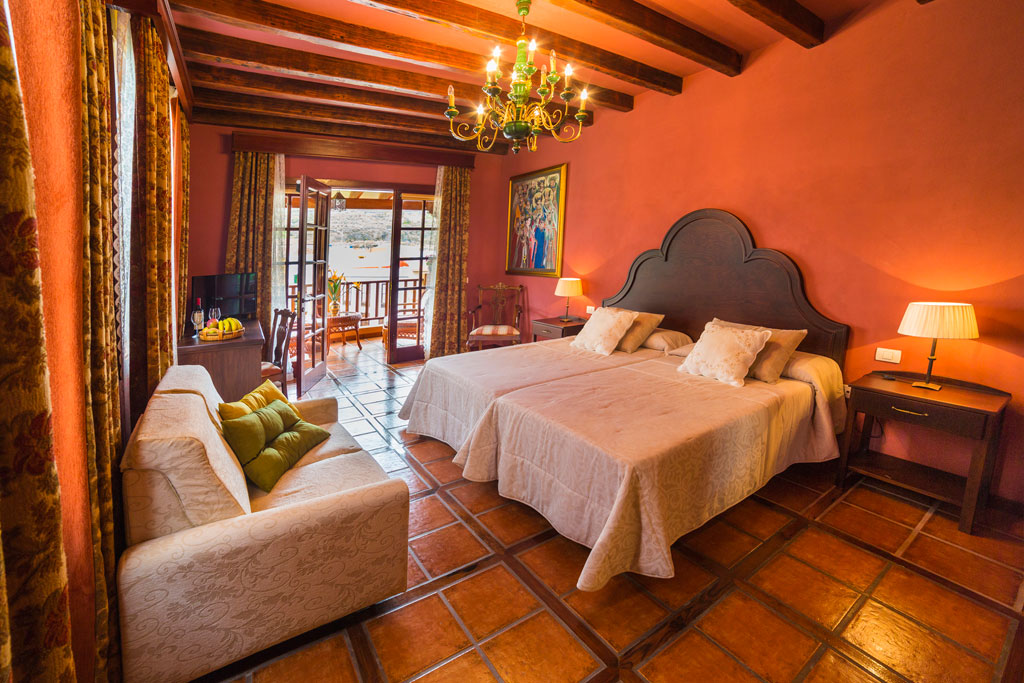Cozy bedroom with twin beds and balcony view in Tenerife hotel.