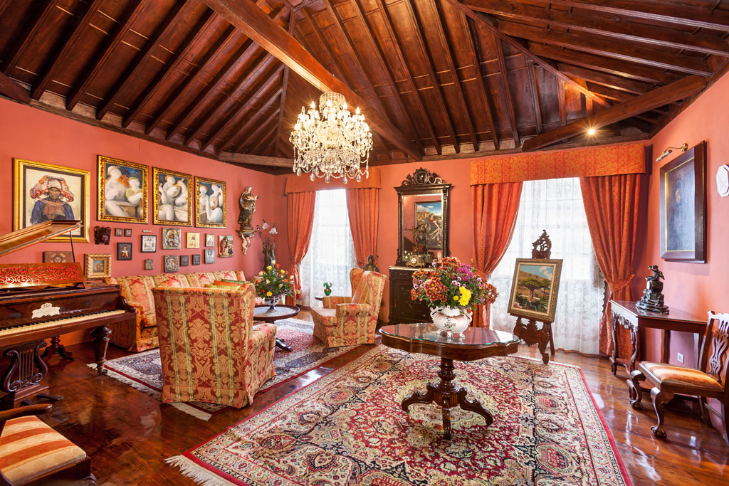 Elegant living room with chandelier, paintings, and antique furniture in Tenerife.