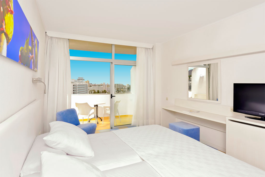 Hotel room in Tenerife with balcony view and minimalist decor.