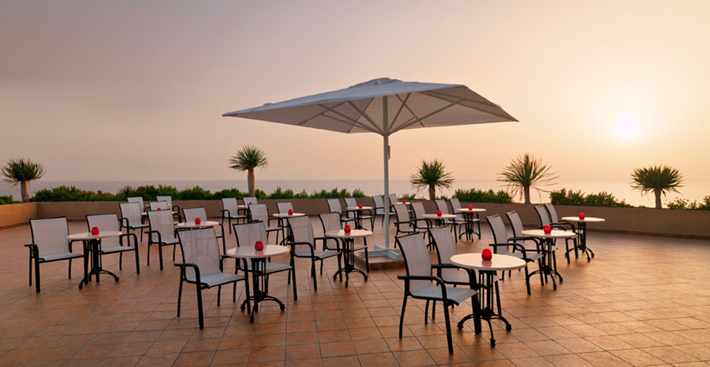 Outdoor terrace with tables and chairs at sunset in Tenerife.