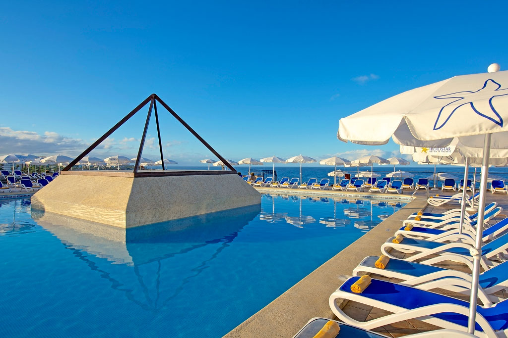 Pyramid-shaped pool with sun loungers and umbrellas at Iberostar in Tenerife.