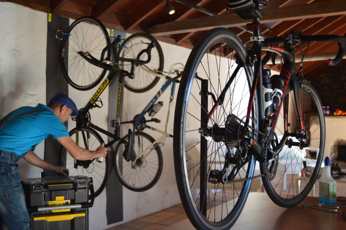 Worker repairing bikes in a Tenerife workshop with tools.