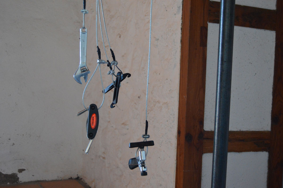 Climbing gear and tools hanging from wires in a Tenerife climbing spot.