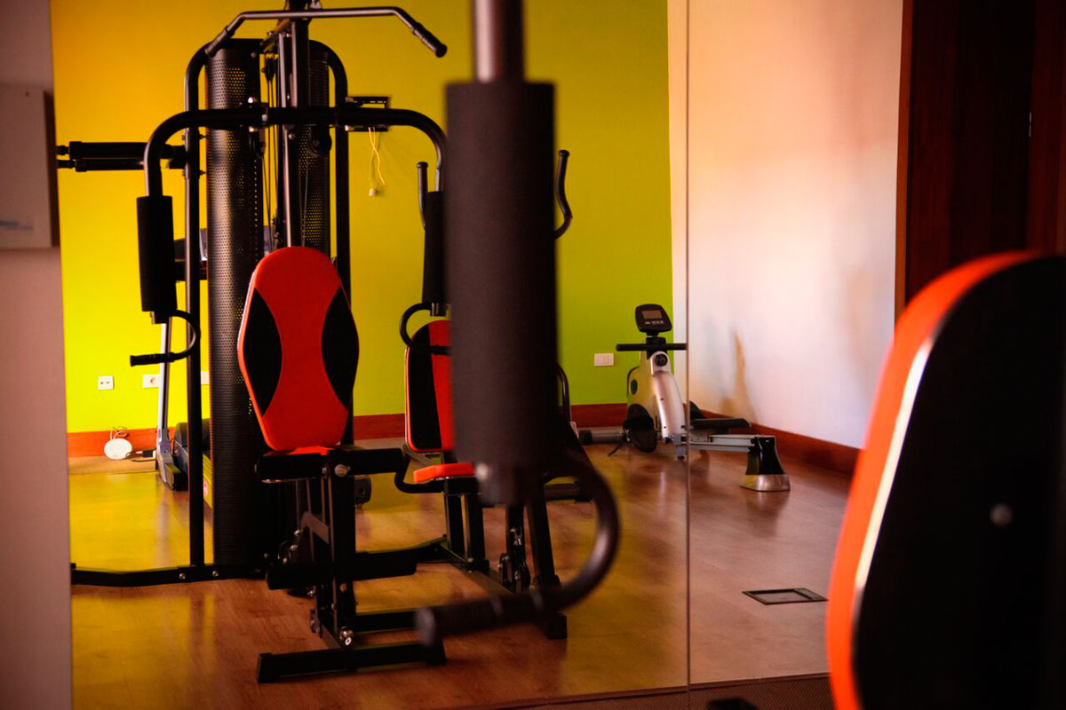 Gym equipment in a room with green walls in Tenerife.