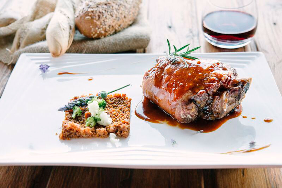 Roasted meat with sauce, quinoa and vegetables on a plate in Puerto de la Cruz.