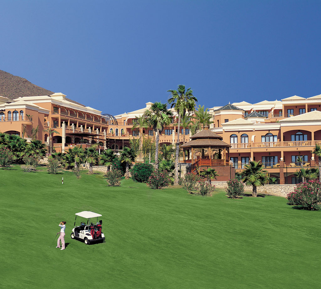 Golfer on course with hotel in Tenerife.