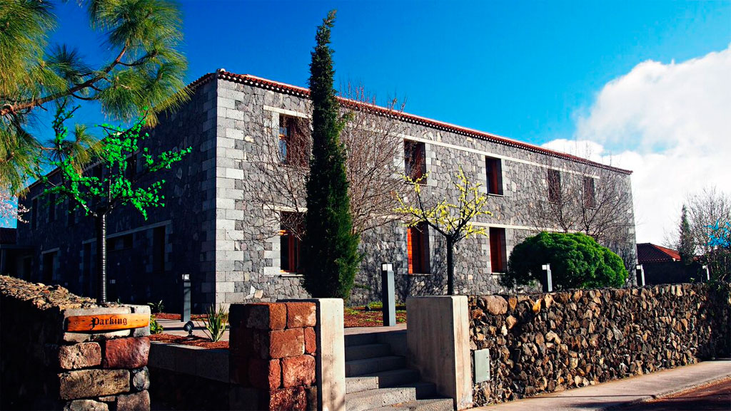 Stone building with trees in front, sign reads Parkung, in Tenerife.
