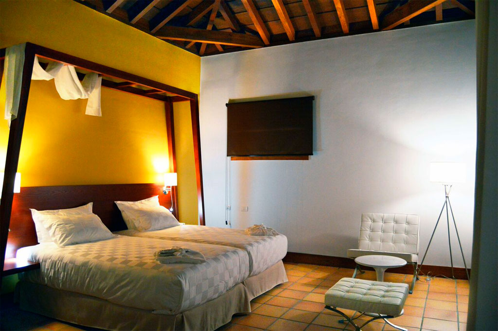 Double bed room with modern decor and white armchair in Tenerife.