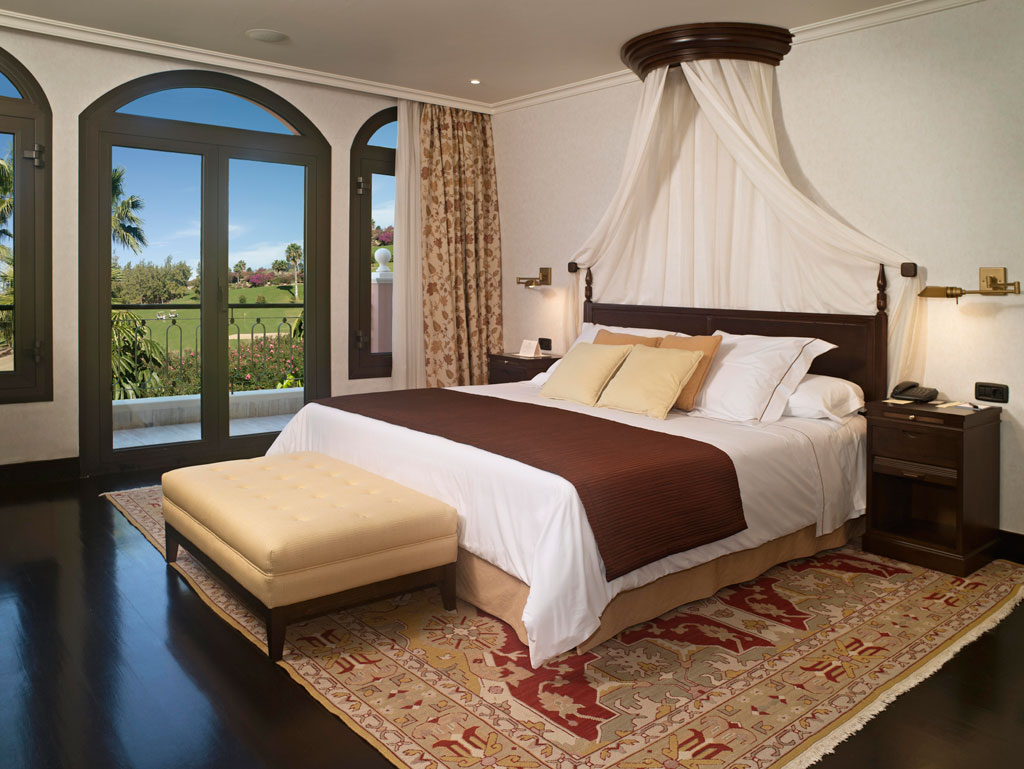 Luxury bedroom with canopy bed and garden view in Tenerife hotel.