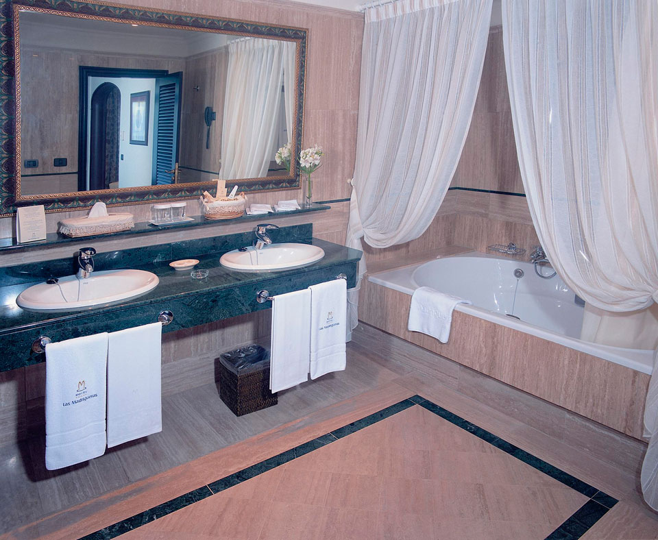 Bathroom with double sinks, mirror, and tub at Las Madrigueras, Tenerife.
